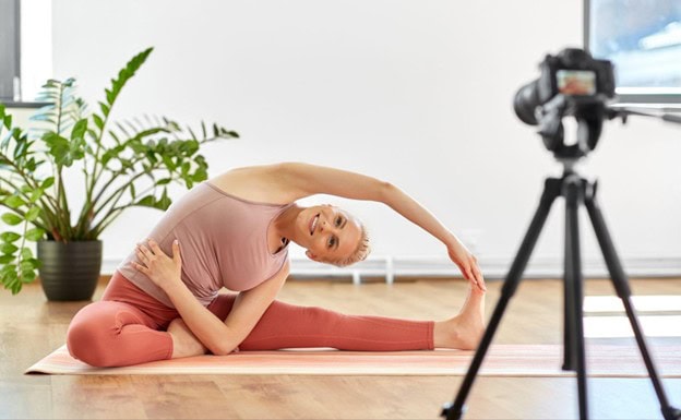 A woman doing exercise in front of a camera